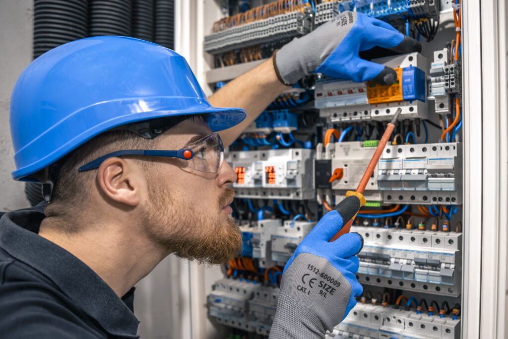 male-electrician-working-switchboard-with-fuses